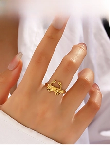 Gros plan d'une bague crabe dorée portée au doigt montrant les détails de l'animal