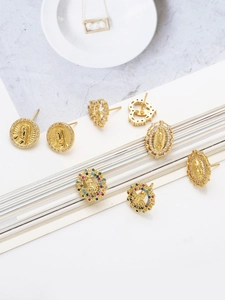 Detailed view of vintage gold coin earrings with colorful zircons and religious icons