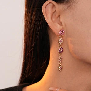 Gros plan de boucles d'oreilles fleurs en cristal rose à cinq couches dorées