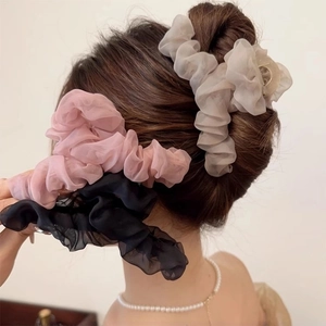 Close-up of elegant pleated mesh hair claw clips in pink beige and black colors