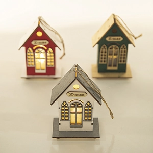 Three glowing Christmas wooden cabins in red, green, and grey with warm LED lights