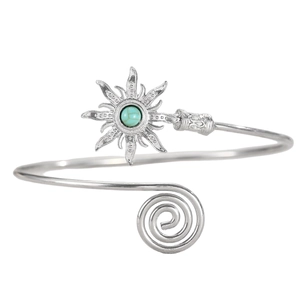 Detail of silver arm cuff featuring a sunburst motif with turquoise stone and spiral design