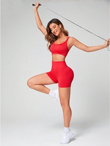 Dettaglio del set yoga rosso con reggiseno sportivo e pantaloncini fitness a vita alta