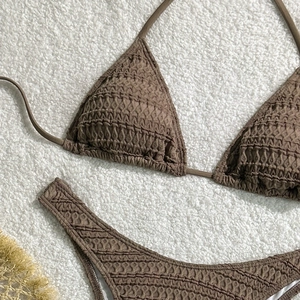 Detail view of brown smocked fabric bikini set with drawstring ties on soft background