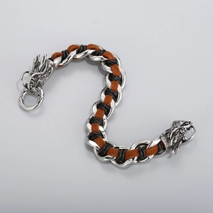 Detalle del cierre de cabeza de dragón plateado en pulsera de cuero trenzado para hombre