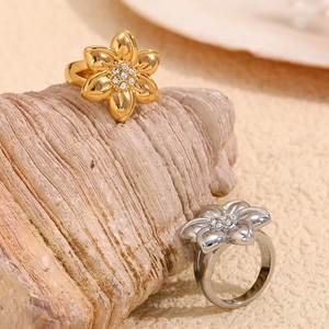 Detailed view of floral rings in gold and silver finish with white zircon centerpiece