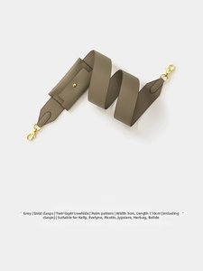 Detail view of grey cross-grain leather shoulder strap with gold buckle and mini pouch