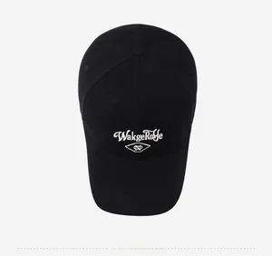 Top down view of black cotton baseball cap showing white embroidery and crown button