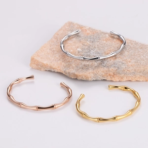 Minimalist bamboo joint bangles in silver gold and rose gold finish on stone display