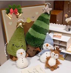 Close-up of plush Christmas tree pillows, white snowmen, and a brown reindeer soft toy