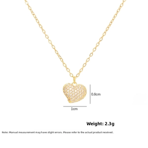 Close-up of gold heart pendant with pavé cubic zirconia measuring 1cm by 0.8cm