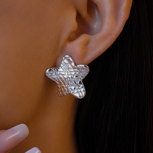Gros plan sur la boucle d'oreille étoile en argent avec surface métallique texturée
