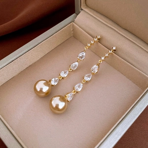Detail of drop earrings with champagne pearls and sparkling marquise crystals