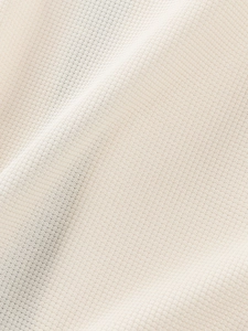 Close-up of the waffle knit fabric texture on a cream white men's short sleeve shirt