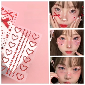 Close-up of red heart gems and silk bow face stickers for creative fairy makeup looks