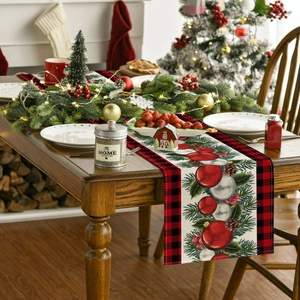 Red black plaid Christmas table runner with pine branch and ornament pattern on wood table