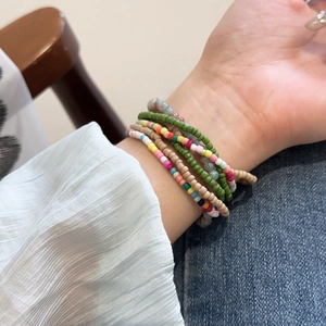 Detail view of multi-layered bohemian seed bead bracelets in vibrant colors on wrist