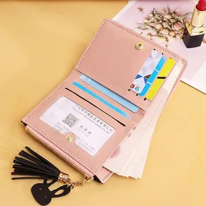 Pink faux leather short bifold wallet with gold hardware and rabbit tassel charm