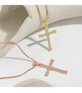 Close-up of gold and rose gold cross pendants with double-row cubic zirconia inlay