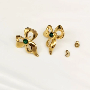 Elegant gold-tone bow earrings featuring green textured malachite stones on beige background