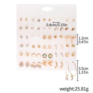 Macro view of gold-tone earring set with crystal heart, butterfly, and moon charms