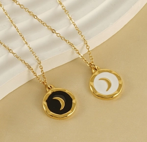 Detail of 18K gold plated necklaces with black and white enamel moon pendants