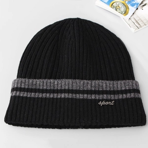 Detailed view of black ribbed knit beanie featuring sport metal tag and grey stripe accent