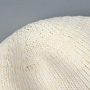 Macro view of the breathable white knitted texture on a stylish summer aviator hat.