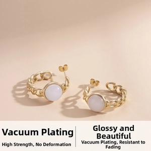 Vue détaillée de boucles d'oreilles dorées en C avec résine blanche et texture chaîne
