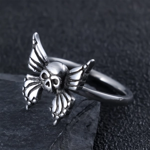 Macro view of gothic skull and butterfly wing ring on dark stone in vintage silver