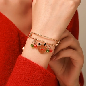 Adjustable Christmas bangle with reindeer charm and colorful beads on a red sweater background