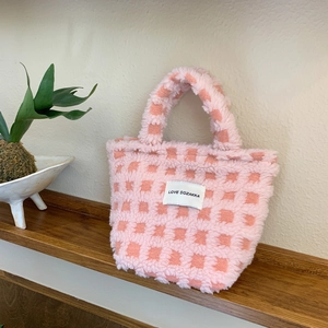 Close-up of pink checkered lamb wool tote bag with LOVE SOZAKKA label on wood shelf