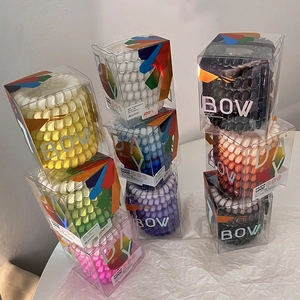 Detail view of colorful spiral hair ties stored in transparent PVC gift packaging boxes