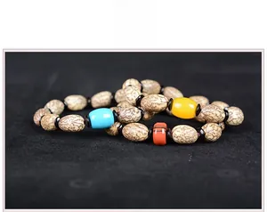 Makroaufnahme von Natur-Bodhi-Armbändern mit blauen und bernsteinfarbenen Perlen auf Schwarz