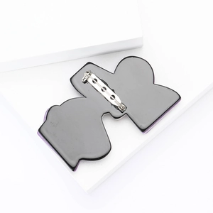 Macro shot of the back of the acrylic brooch showing the secure silver metal safety pin clasp
