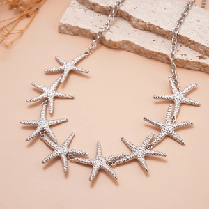 Close-up of silver starfish choker necklace featuring multi-link beach charms