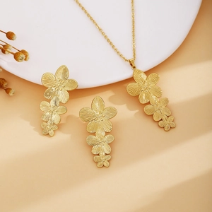 Close-up of gold flower necklace and earrings set with detailed metallic textures