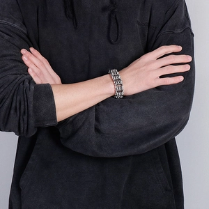 Detailed view of heavy vintage stainless steel dragon chain bracelet on a male model's wrist