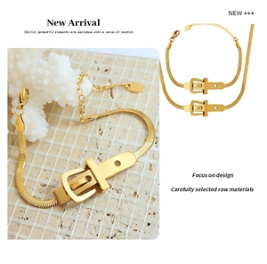 Détail d'un bracelet chaîne serpent dorée avec un charme géométrique de style boucle de ceinture