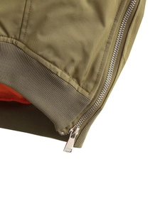 Détail de la veste aviateur verte avec fermeture éclair en métal et doublure