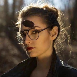 Retro steampunk flip-up sunglasses with metal round frame on a model in nature