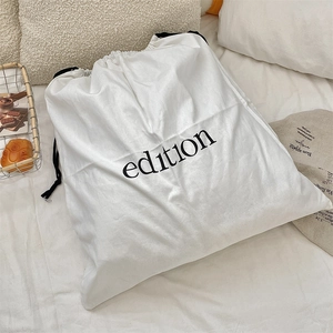 Detail of white cotton linen drawstring storage bag with black edition text print