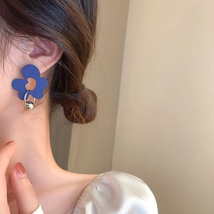 Detail of Klein Blue floral earrings featuring a silver metallic sphere on model