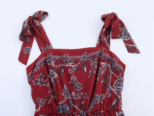 Détail de robe fleurie bordeaux avec bretelles à nœuds et encolure carrée élégante
