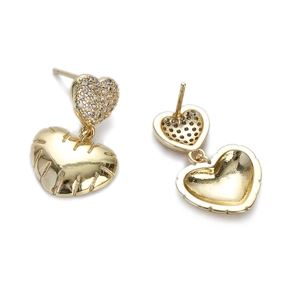 Macro shot of gold heart earrings showing zircon micro-paving and radial texture