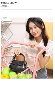 Glossy black PVC jelly bag with a unique triangular handle shown in a lifestyle setting
