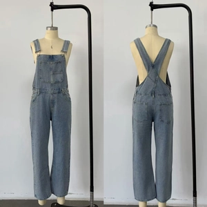 Detail view of blue cotton denim overalls showing front large pockets and back pockets