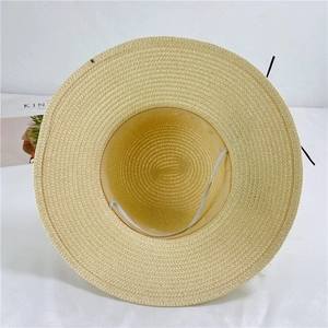 Internal view of beige straw sun hat with white elastic chin strap and woven texture