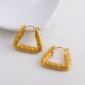 Detailed close-up of 18K gold triangle earrings with intricate twisted rope texture pattern