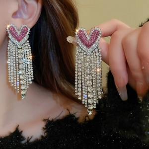 Luxurious pink heart earrings with sparkling tassel fringe shown on a female model